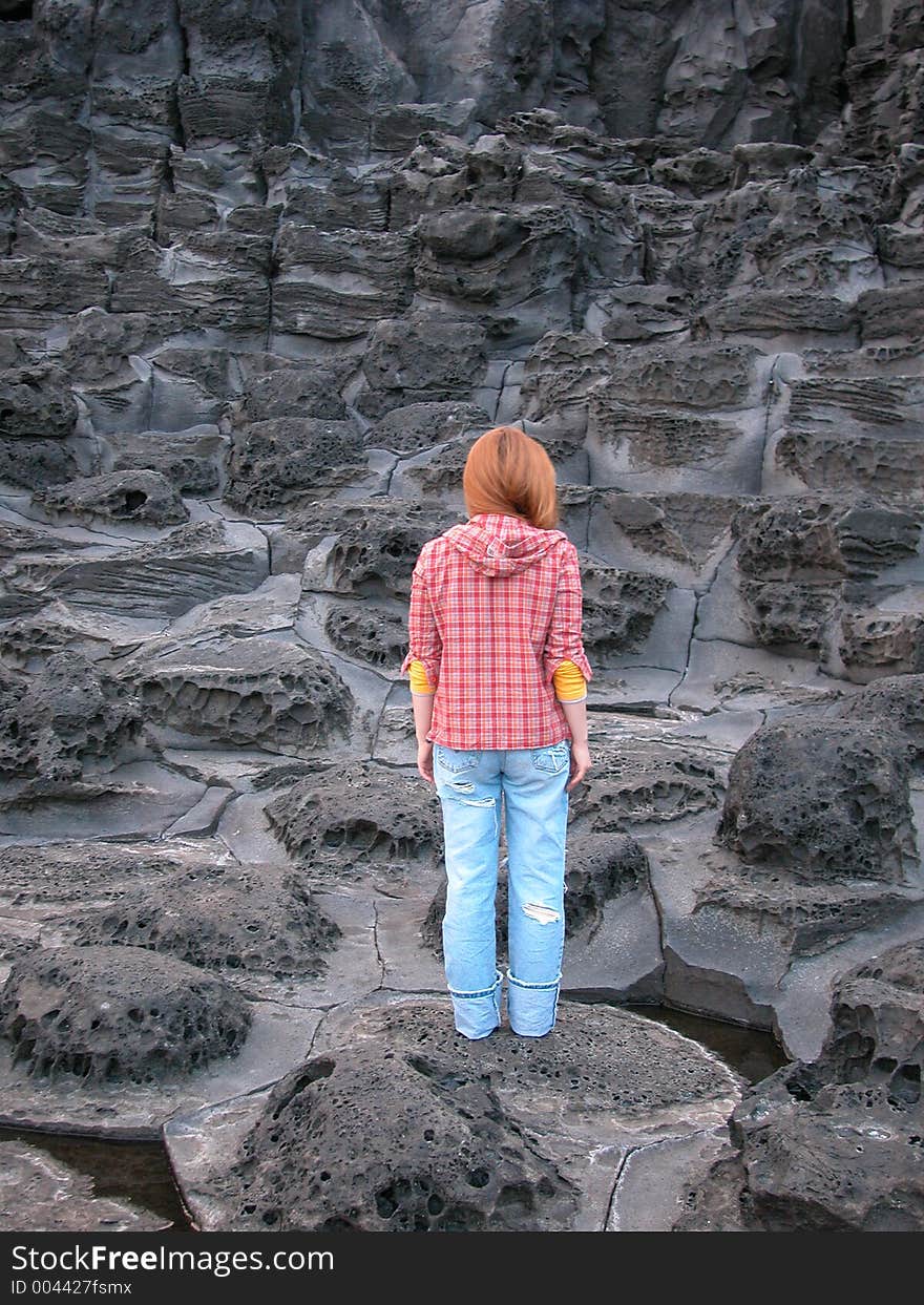 Woman standing on volcanic rock