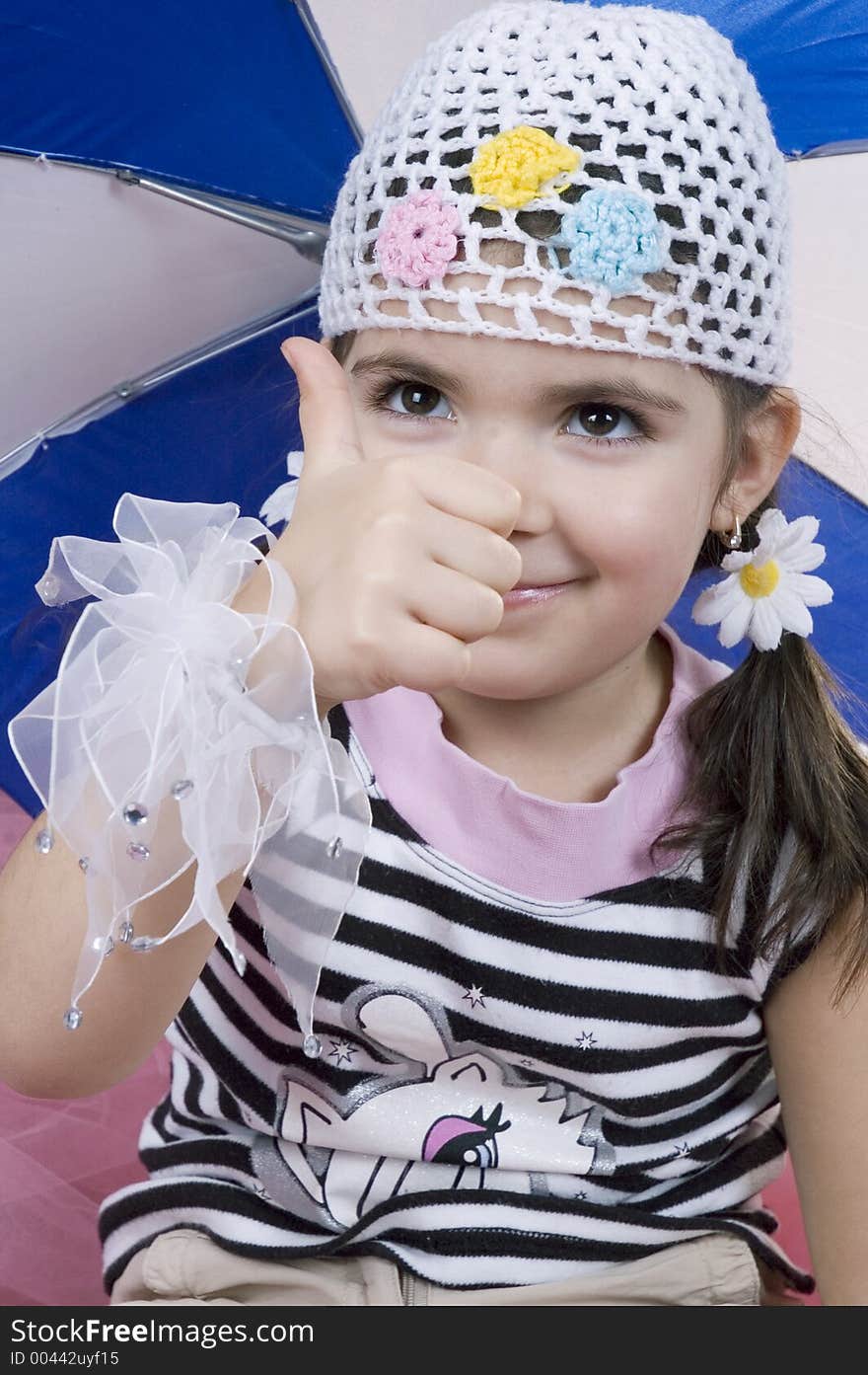 Little girl in a fashionable outfit doing the OK sign. Little girl in a fashionable outfit doing the OK sign