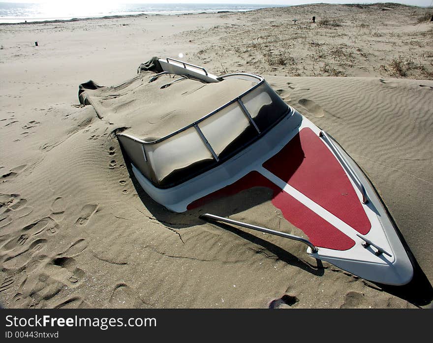 An abandoned speedboat on a beach in china.