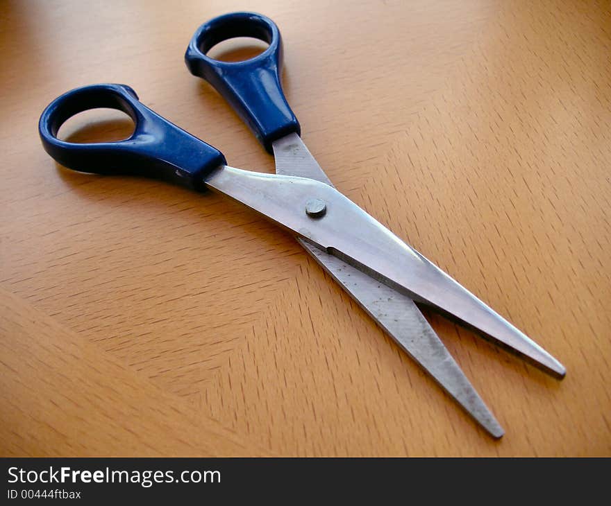 Pair of scissors open on a desk. Pair of scissors open on a desk