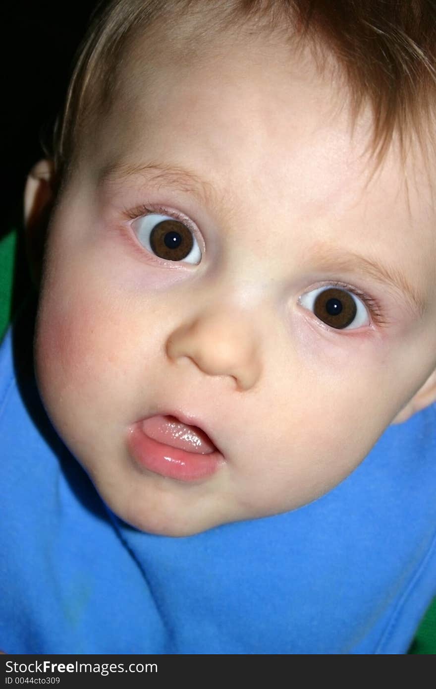 Child caught off-guard while sitting in his highchair waiting to be fed. Child caught off-guard while sitting in his highchair waiting to be fed