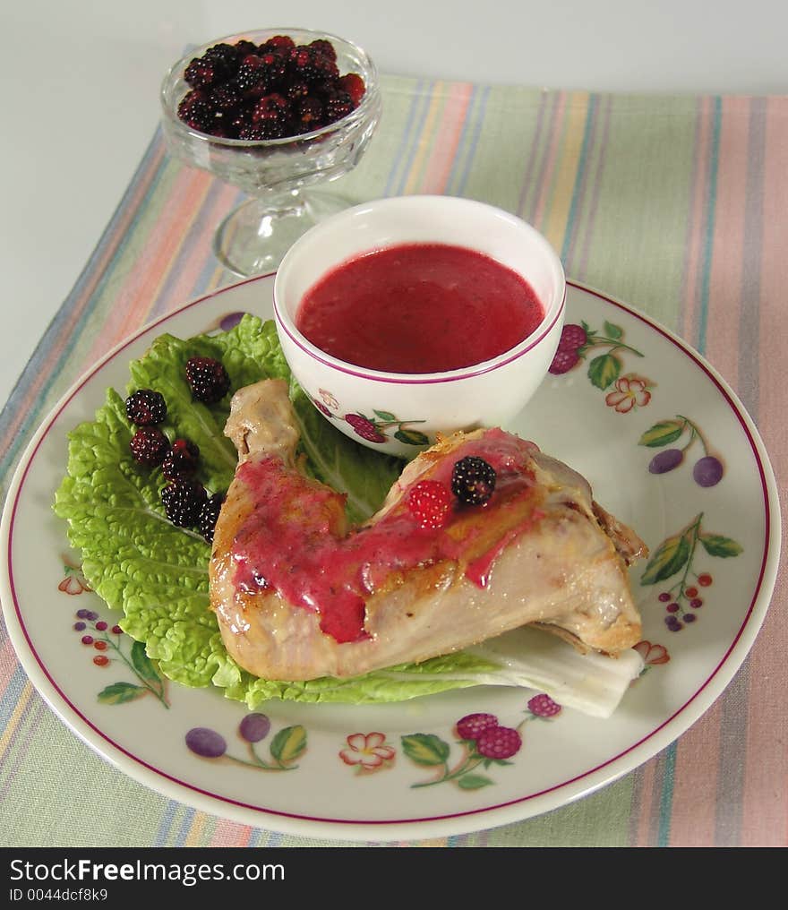 Chicken leg with blackberry sauce on salad leaf