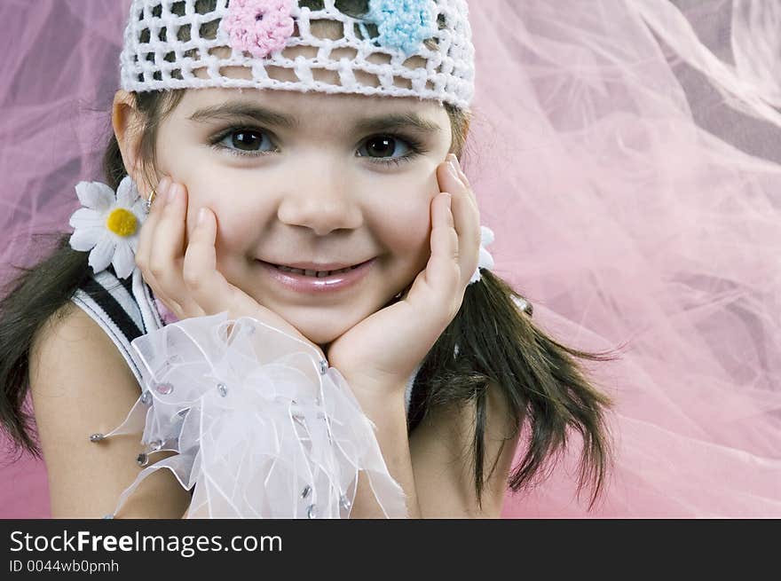 Spoiled little girl poses in all sorts of new clothes on a pink, veil background. Spoiled little girl poses in all sorts of new clothes on a pink, veil background