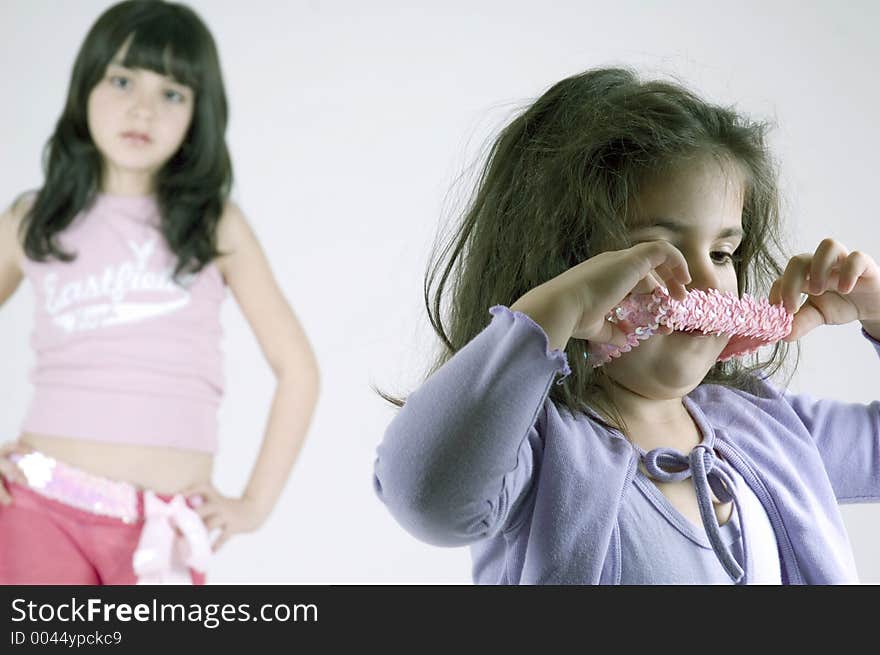 A little girl is upset because her younger sister took her hair band. A little girl is upset because her younger sister took her hair band.