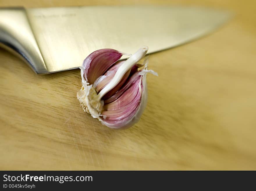 Chef's Knife and garlic on wooden chopping board