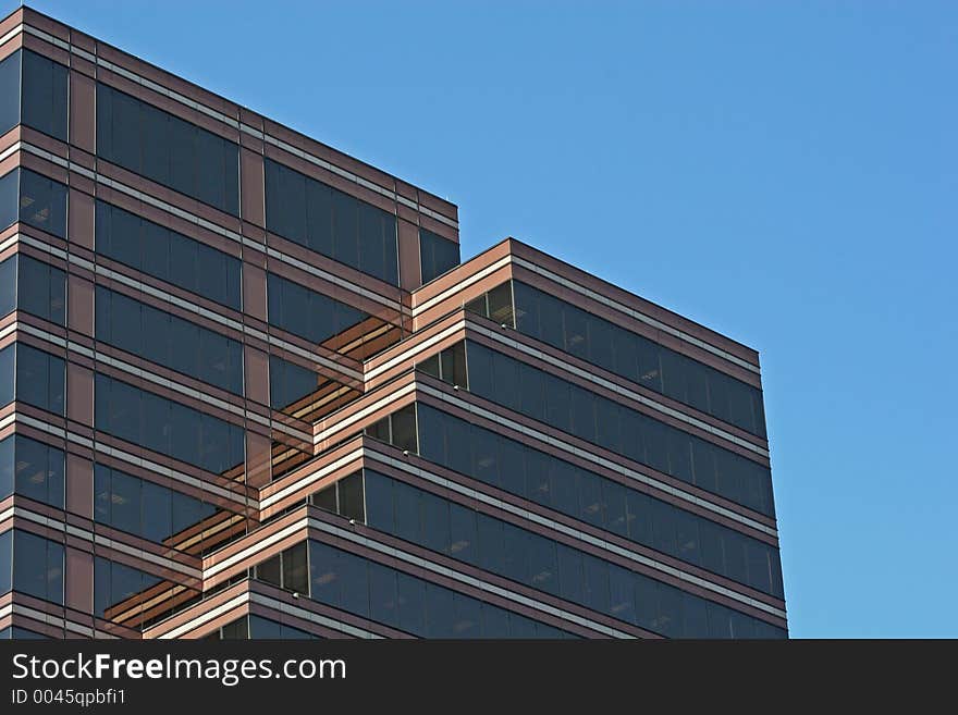 Brick and Glass tower with terraces against sky. Brick and Glass tower with terraces against sky