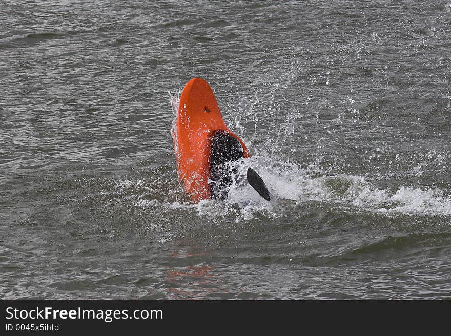 Lone kayaker practicing rollover recovery. Lone kayaker practicing rollover recovery