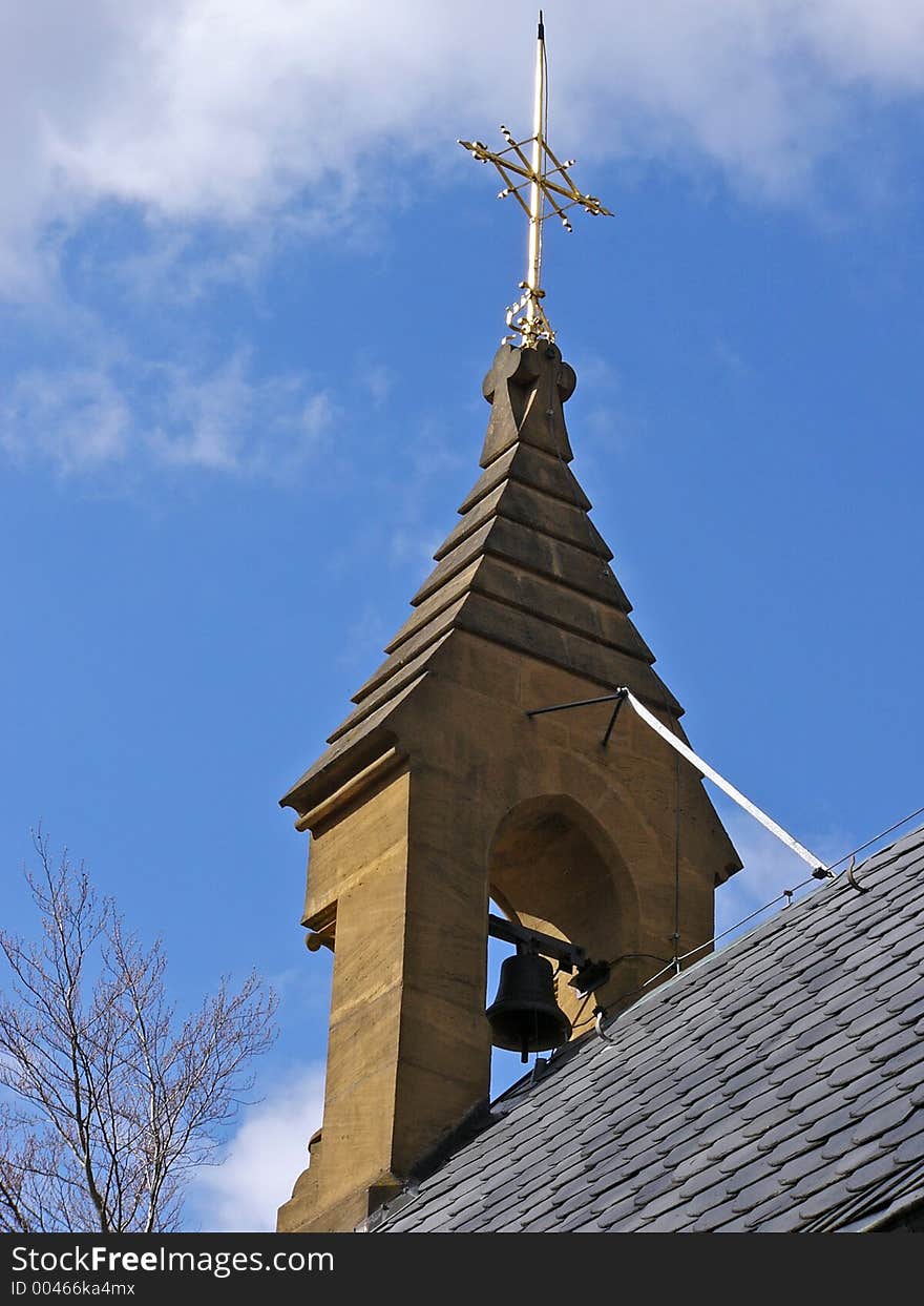 Pilgrimage chapel tower with church bell and golden cross on the rooftop