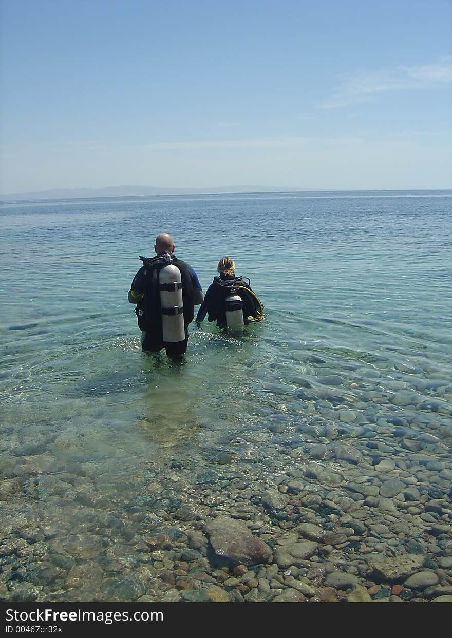 A pair of diver wade out to start their dive. A pair of diver wade out to start their dive