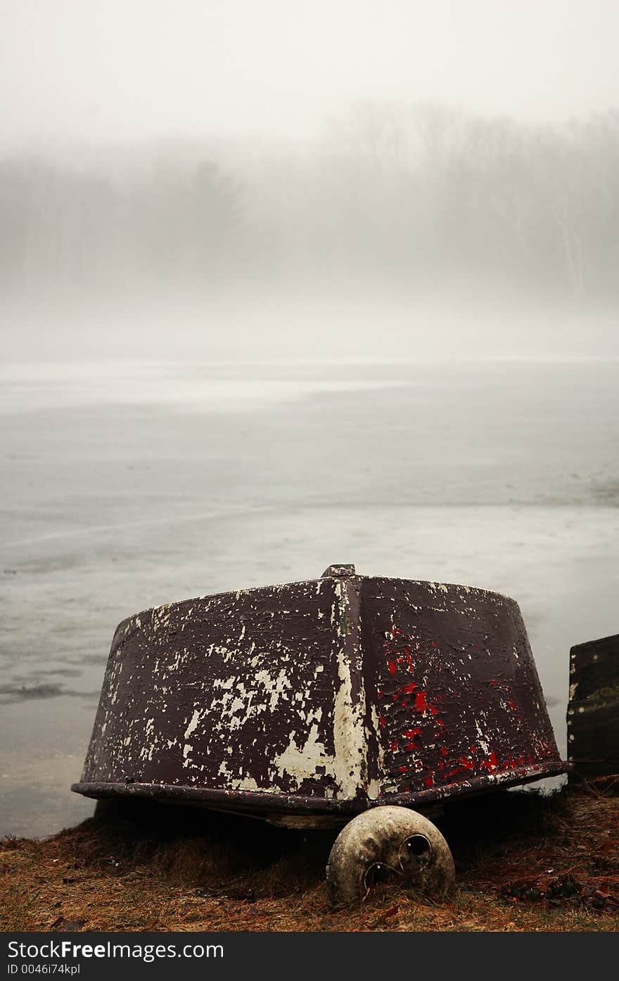 Boat upside down on the edge of a misty pond. Boat upside down on the edge of a misty pond