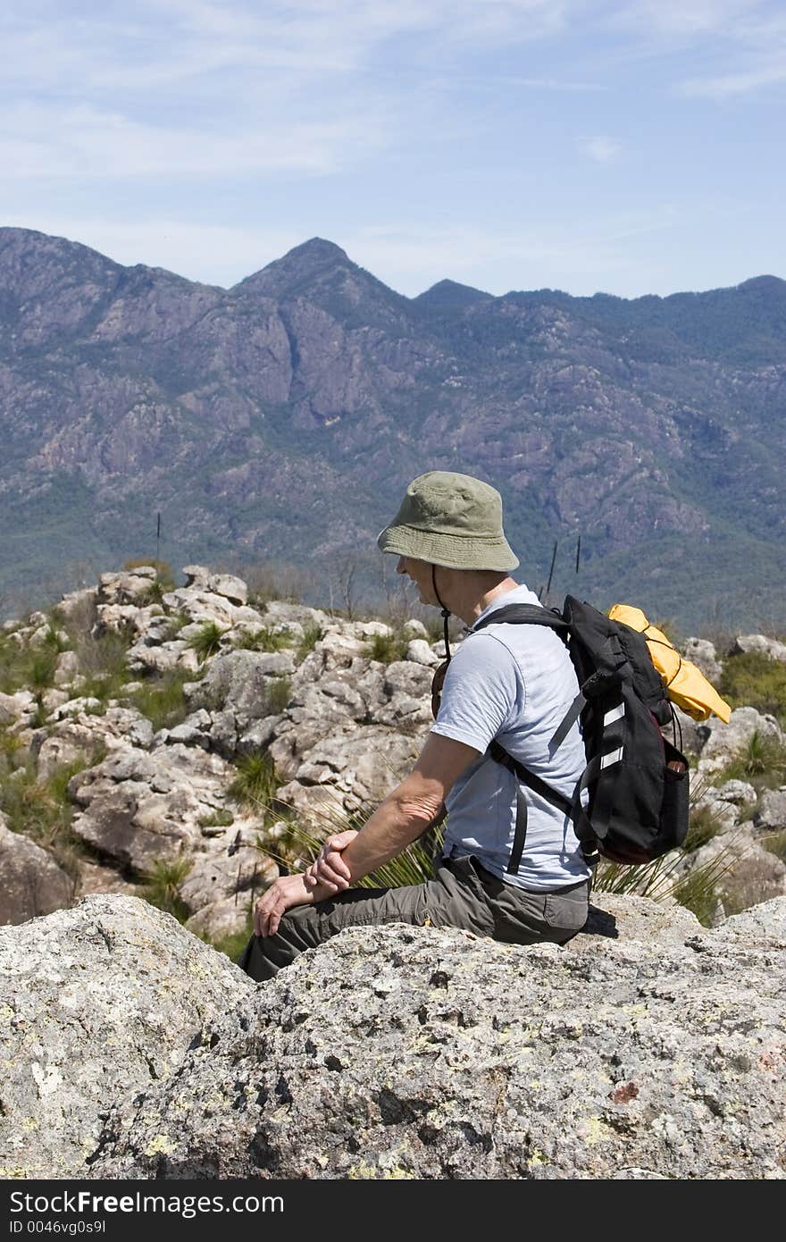 Old man sitting on mountain top 2 portrait