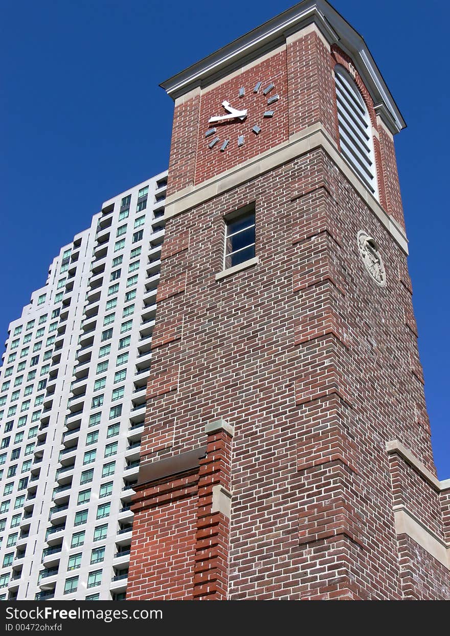 Old brick clock tower in front of brand new condo building. Old brick clock tower in front of brand new condo building.