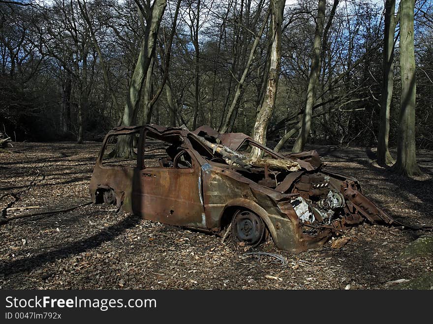 An abandoned burned out car in the woods