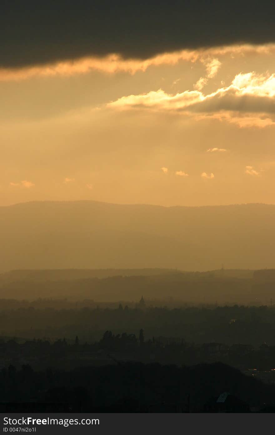 Sunset with nice cloud lighting on the city. Country side and mountains in the back. Sunset with nice cloud lighting on the city. Country side and mountains in the back.