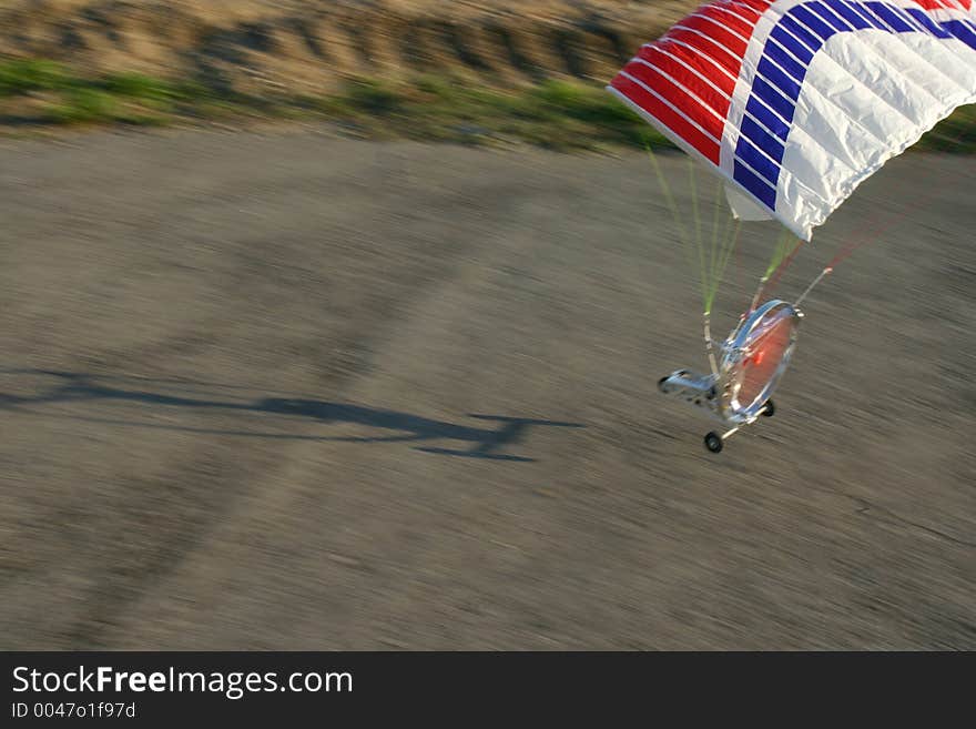 Snapshot of a model paraglider during take-off. Focus is on the wing.