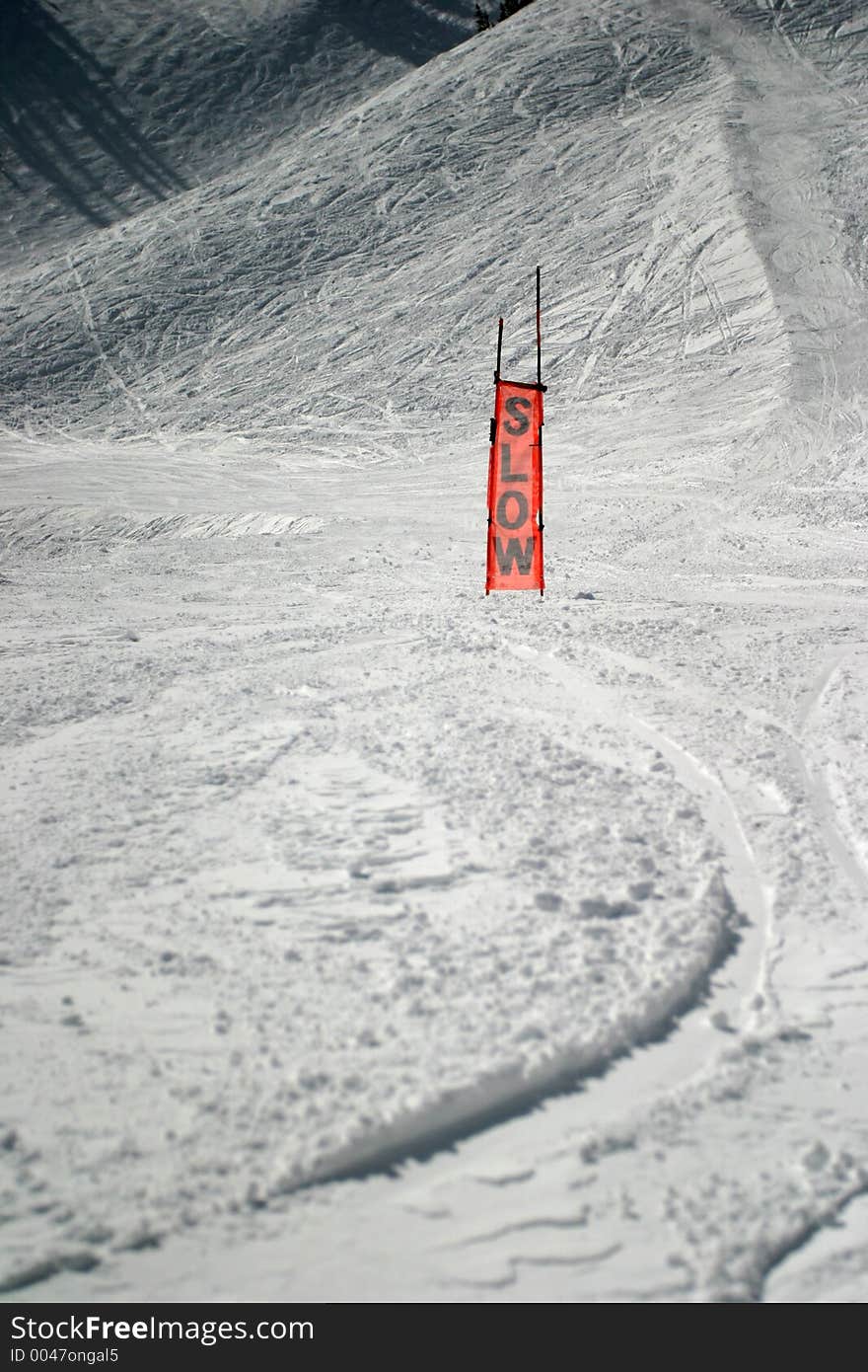 This is an orange sign you see on a ski slope. It is made of a see-through mesh material. Obviously used to caution skiiers to slow down. This is an orange sign you see on a ski slope. It is made of a see-through mesh material. Obviously used to caution skiiers to slow down.