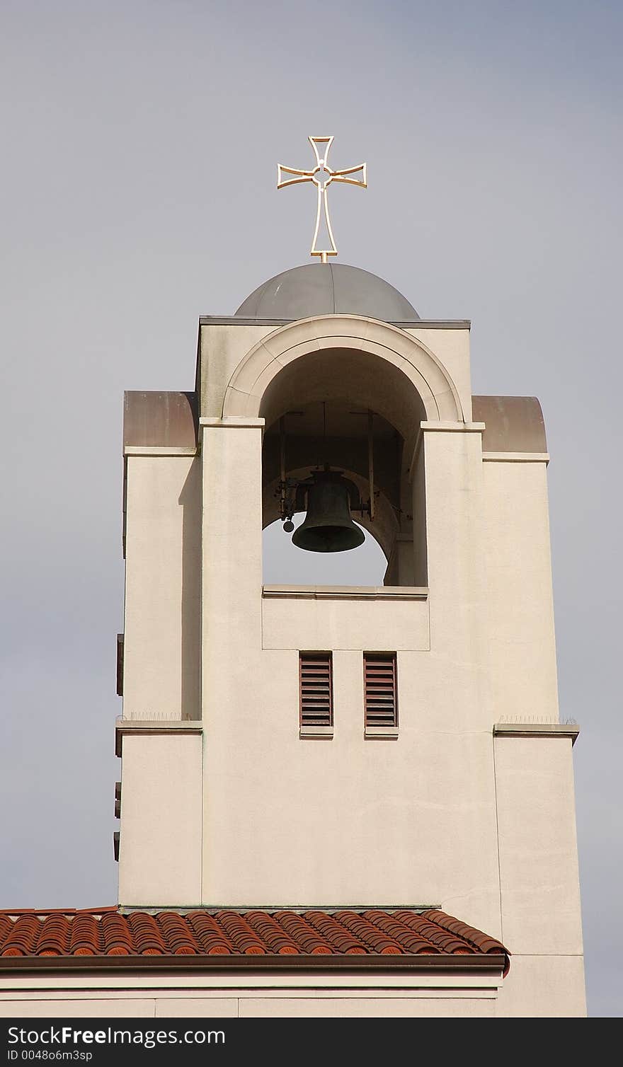 Church steeple, with gold cross and bell.