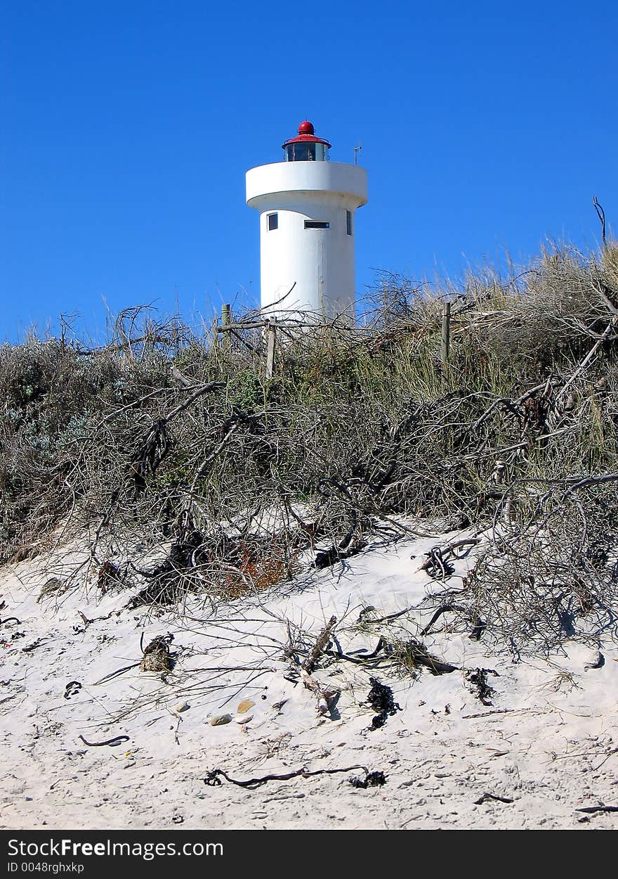 Portrait shot of a coastal dune with lighthouse. Portrait shot of a coastal dune with lighthouse.