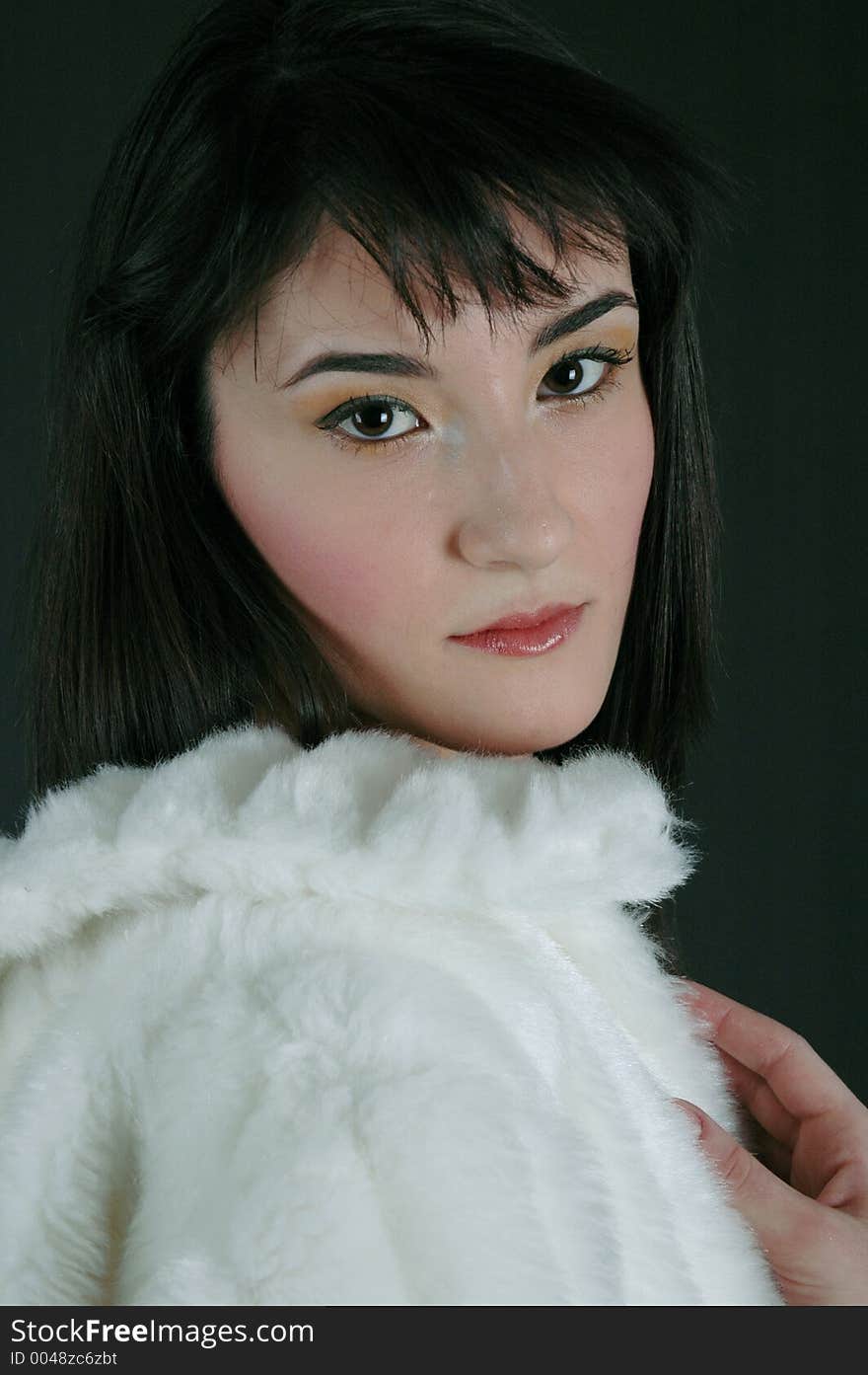 Pretty young woman in a white fancy fur coat. Pretty young woman in a white fancy fur coat.