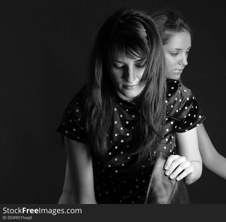 Two thoughtful girls enjoying a silent moment, while the brunette takes off her boots. Two thoughtful girls enjoying a silent moment, while the brunette takes off her boots.