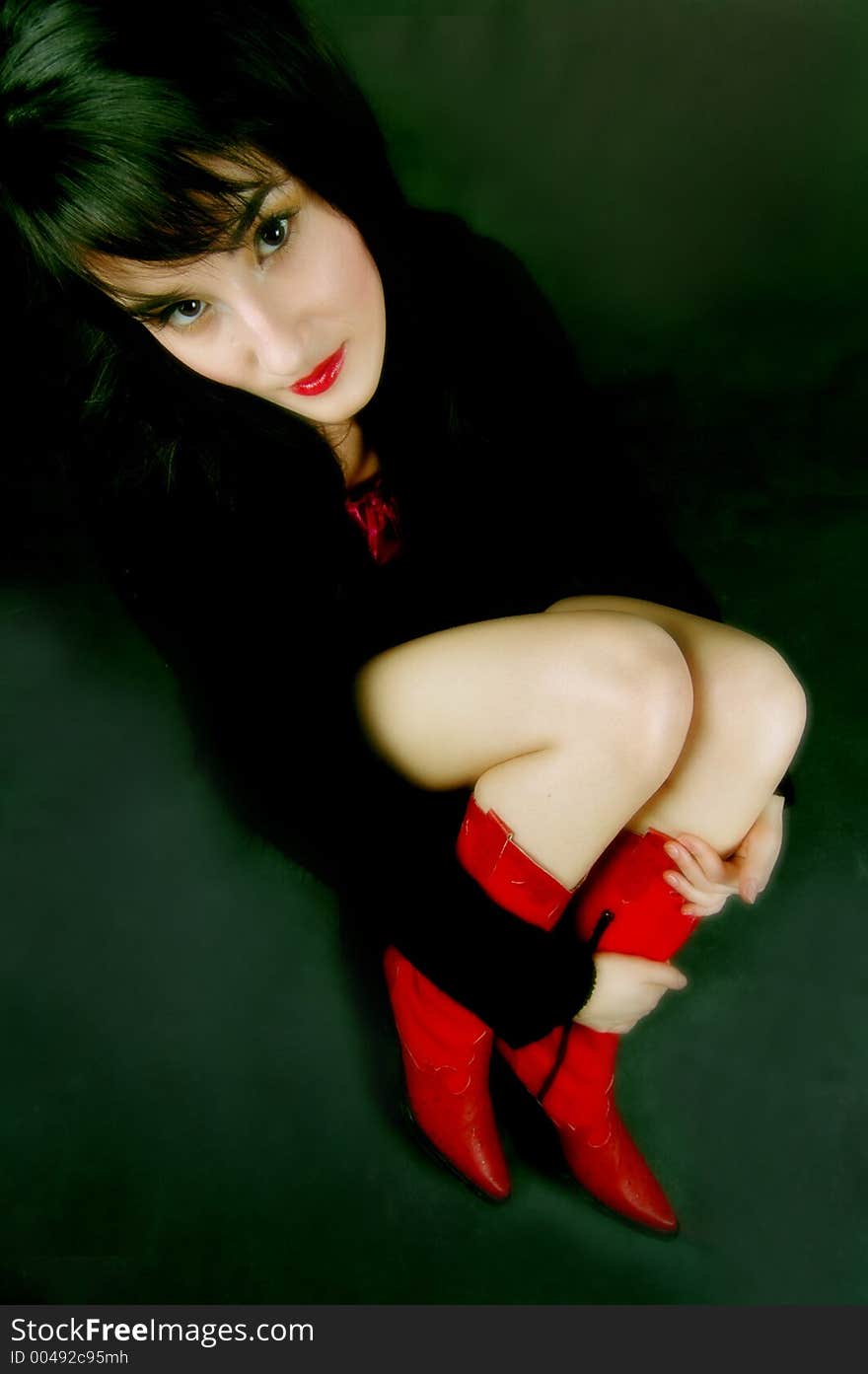 Wide angle shot of woman in red boots, accent on the face. Wide angle shot of woman in red boots, accent on the face