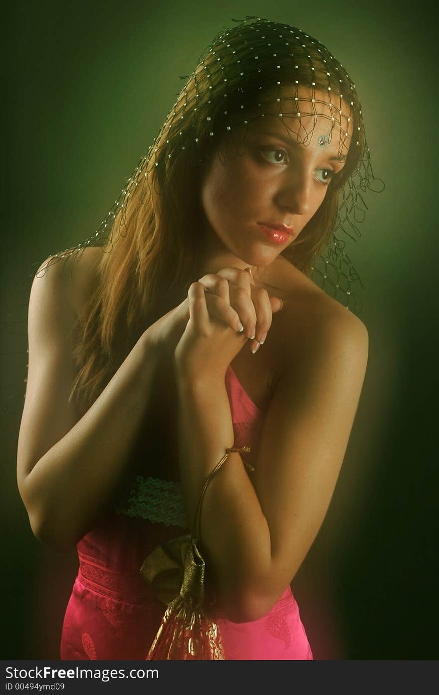 Young hindu woman wearing a bright red dress with her arms together in a prayer.