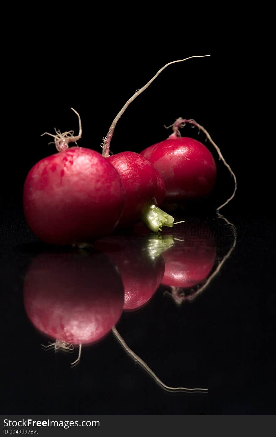 Three red radishs on the black background