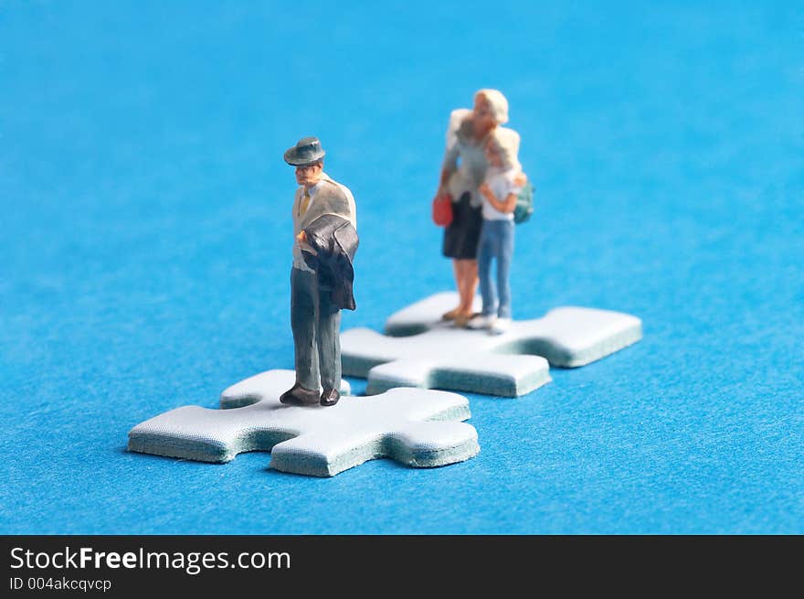 Two plastic figures standing on two puzzle pieces. Two plastic figures standing on two puzzle pieces