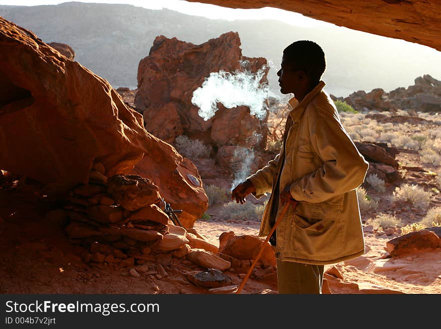 An African man smoking in death valley Namibia