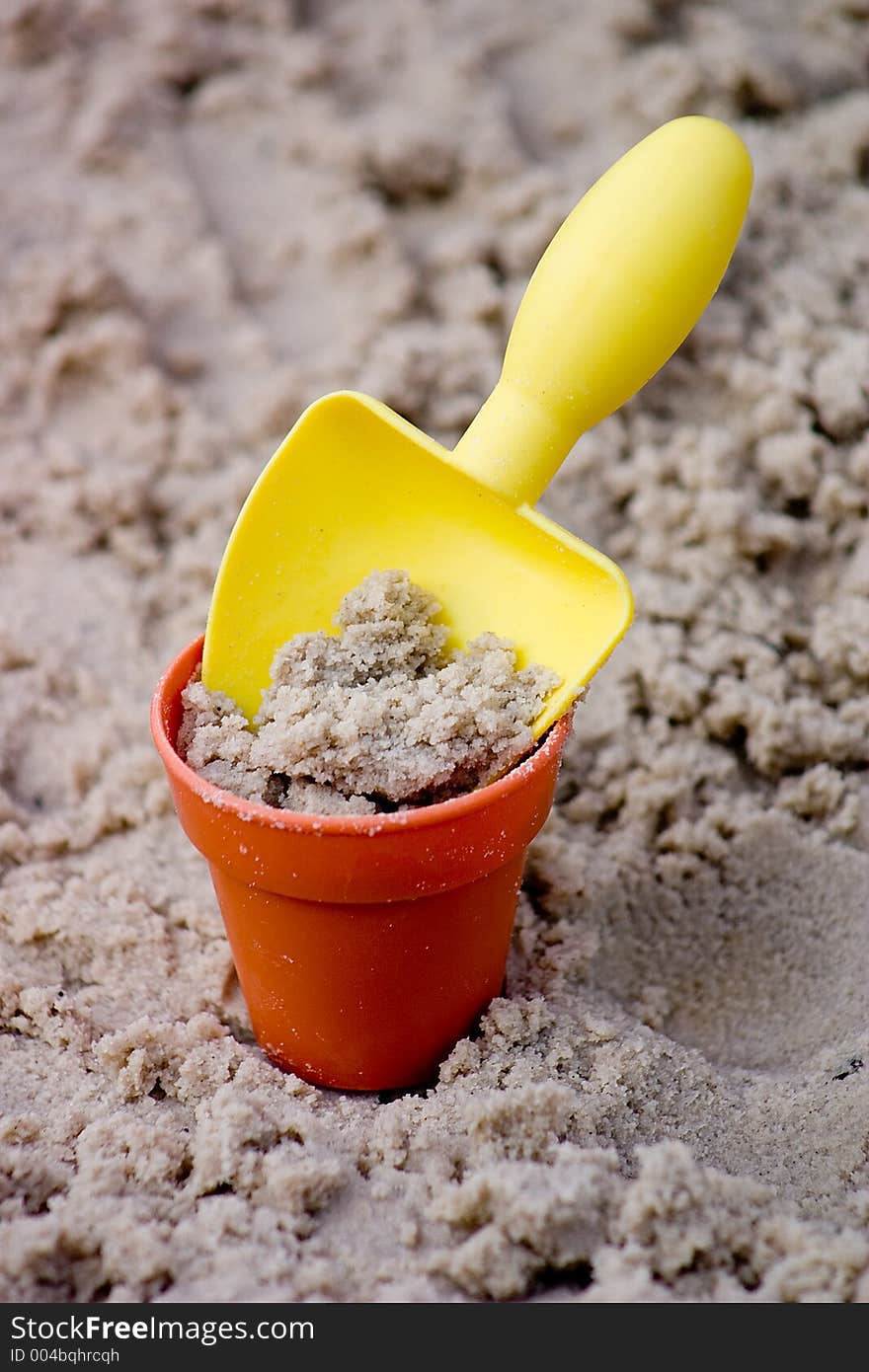 Yellow Small Shovel with Bucket in Sand. Yellow Small Shovel with Bucket in Sand
