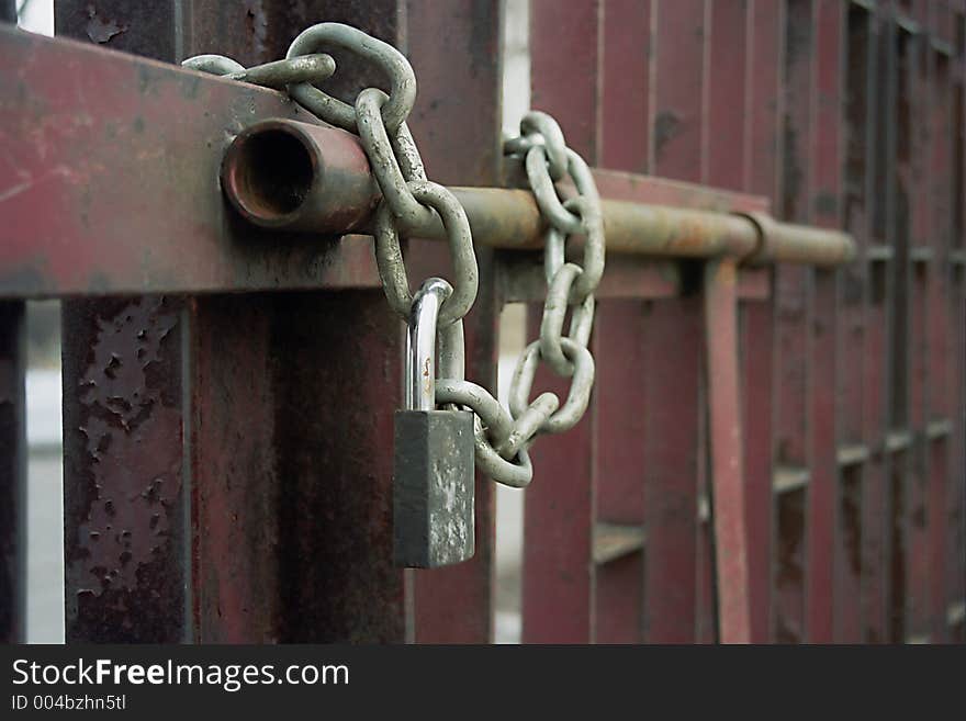 Exterior of padlock and chain on metal gate. Exterior of padlock and chain on metal gate.