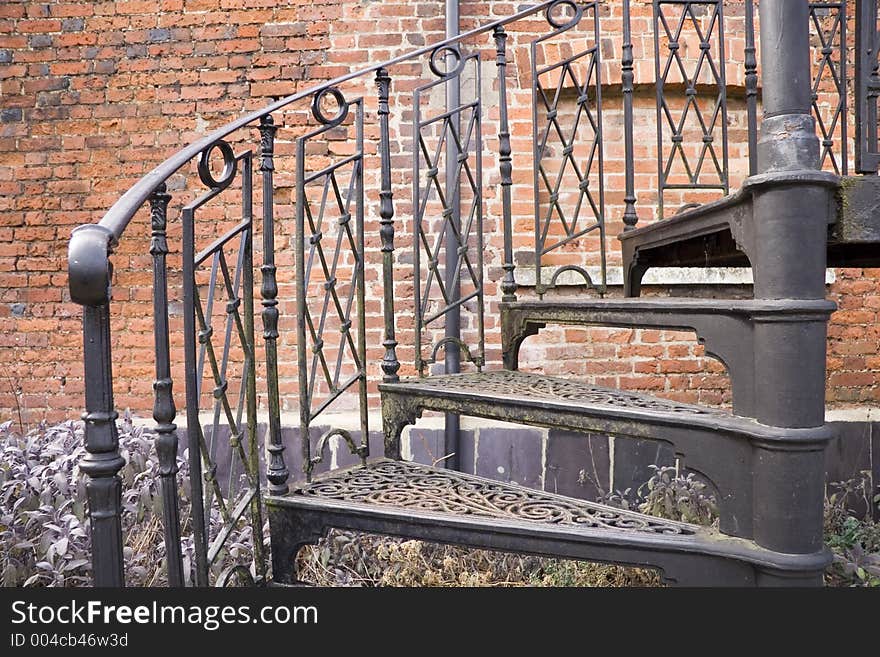 Black metal spirel staircase near a brick wall. Black metal spirel staircase near a brick wall.