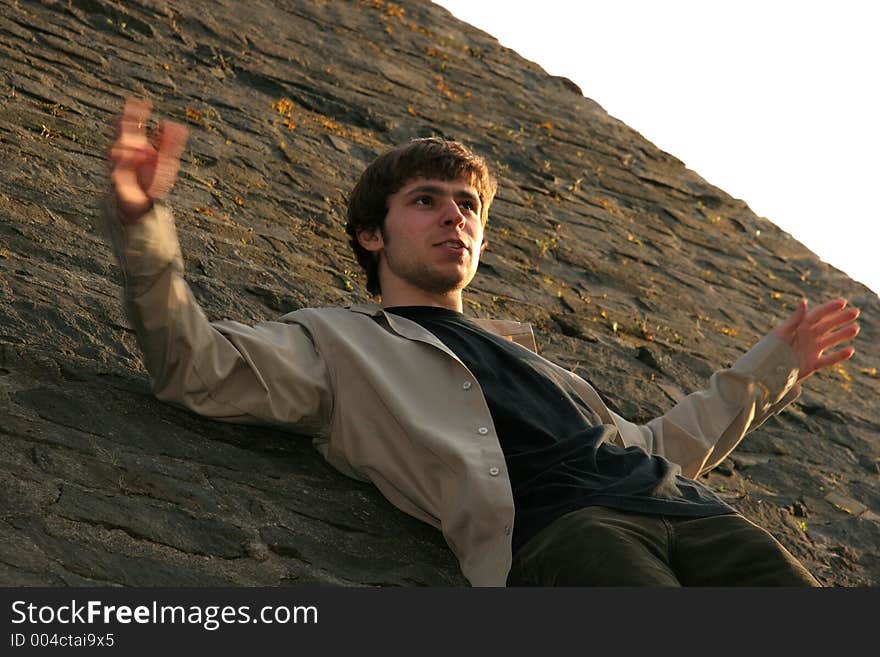 Young man with blured hands and brick wall behind. Young man with blured hands and brick wall behind