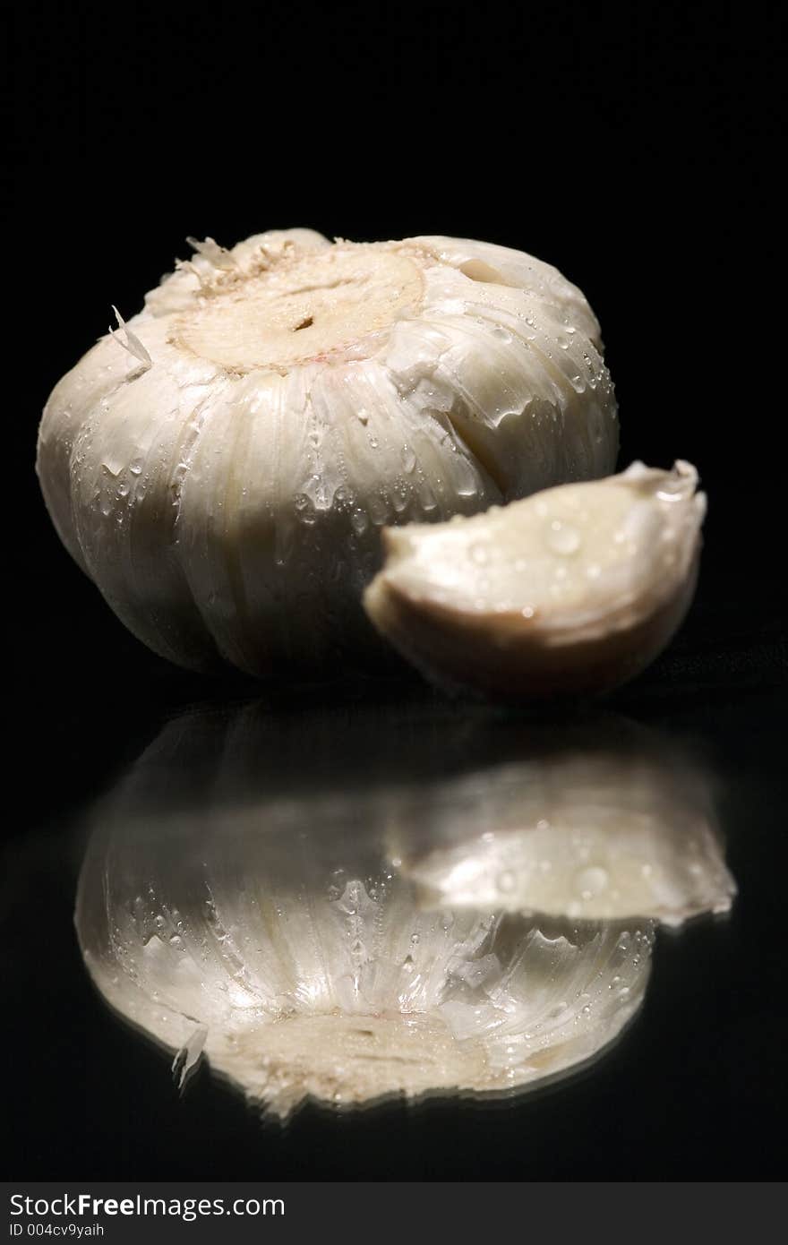 Still life of garlic with reflex on black background