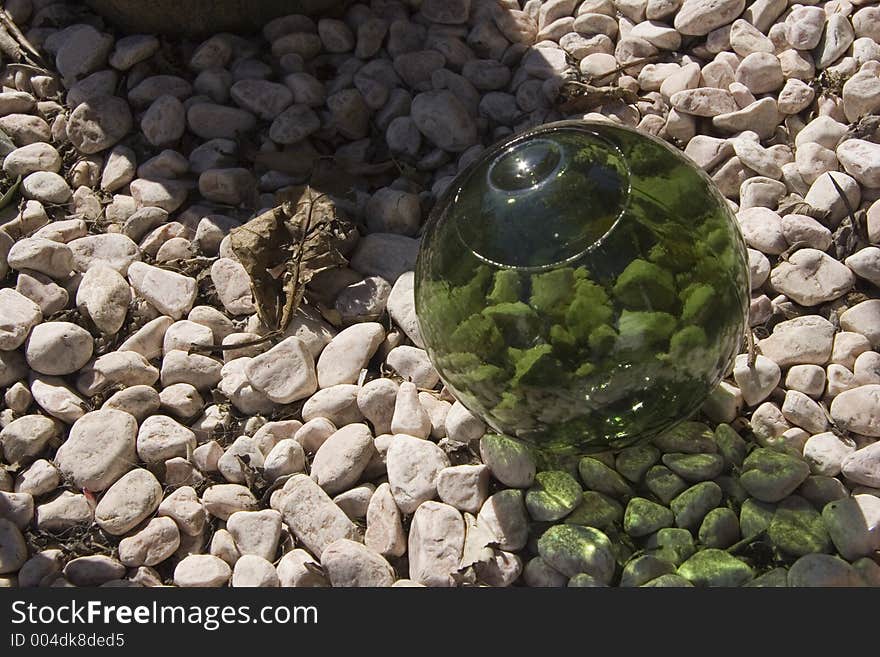 A green glass ball om garden gravel. A green glass ball om garden gravel.