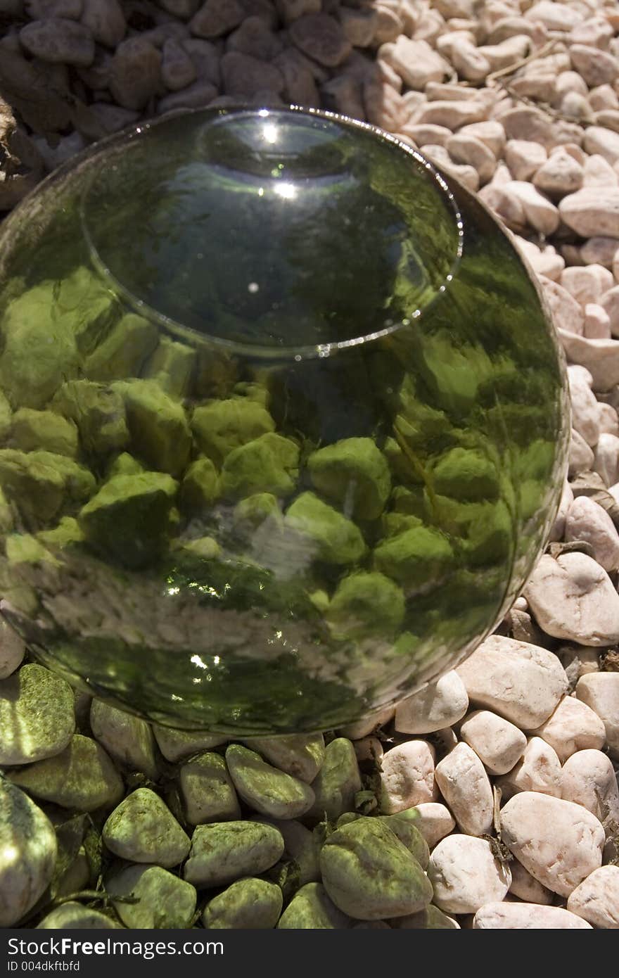 A green glass ball on some gravel. A green glass ball on some gravel.