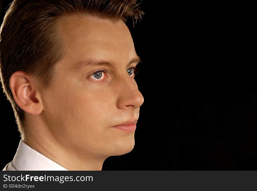 Portrait of attractive young man on isolated black background with copyspace. Portrait of attractive young man on isolated black background with copyspace