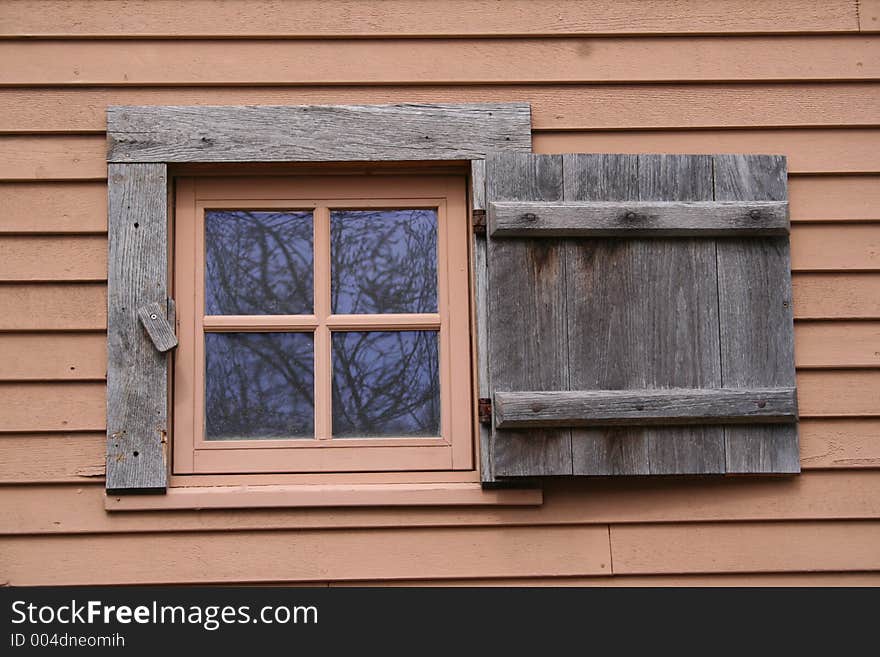 A small,shuttered window on an historic New England building