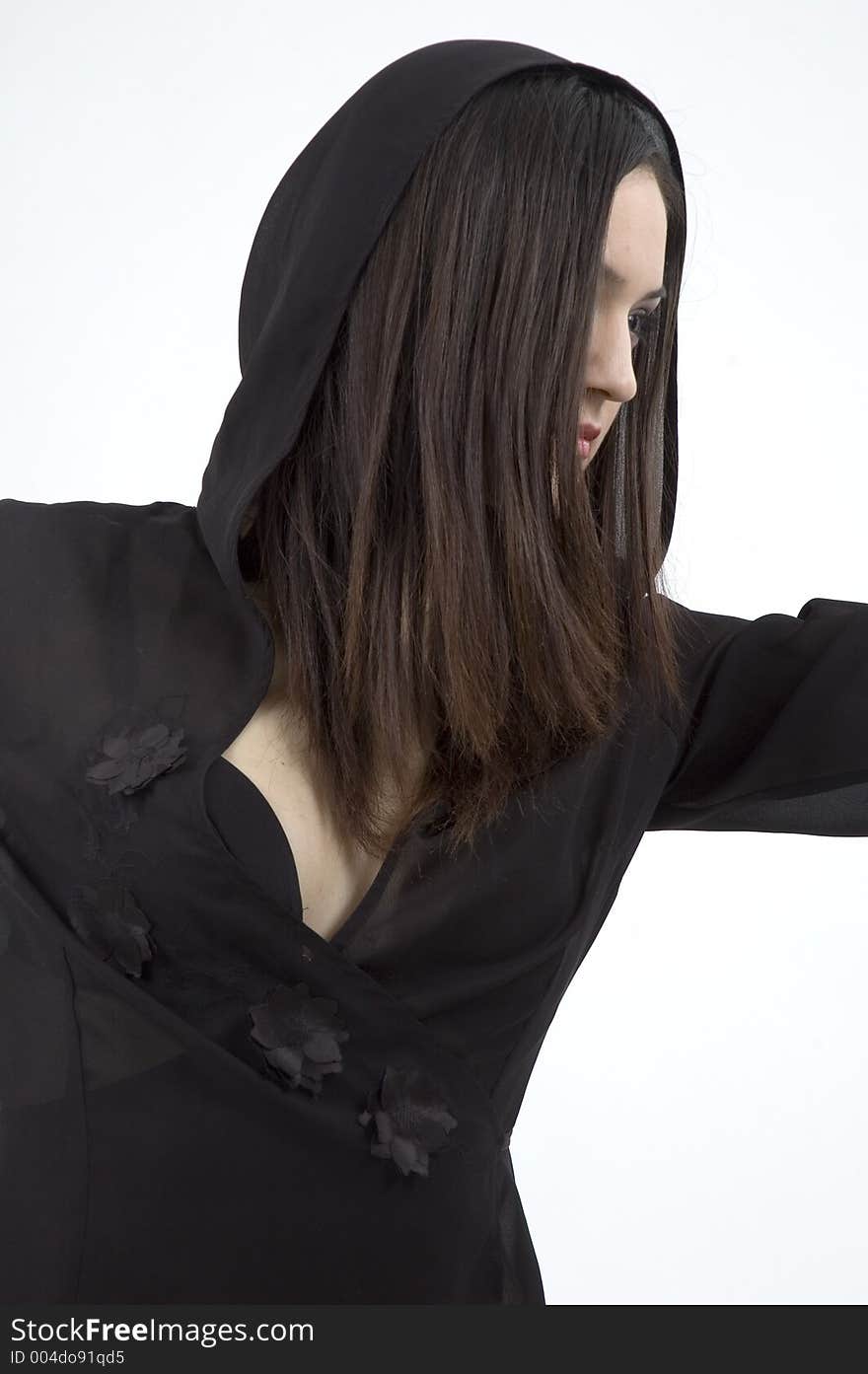 Poetic stance of an adolescent woman dressed in black, wearing a hood.
