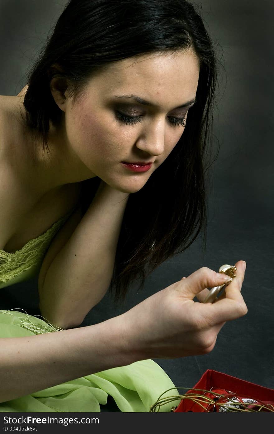 Pretty young woman dressing up for a night out, deciding on the perfect earrings to go with her outfit. Pretty young woman dressing up for a night out, deciding on the perfect earrings to go with her outfit.