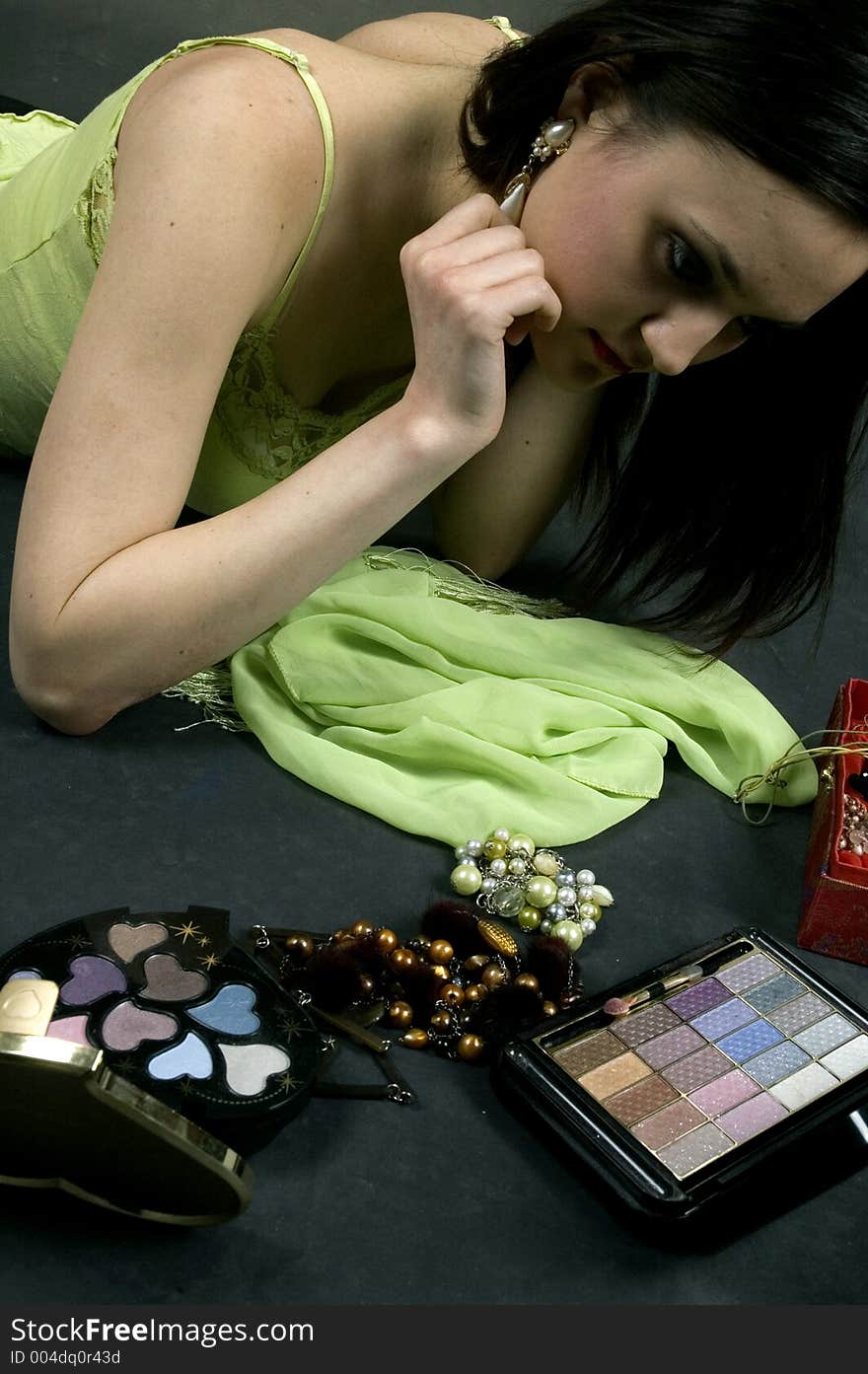 Pretty young woman applying the final touches to her outfit.