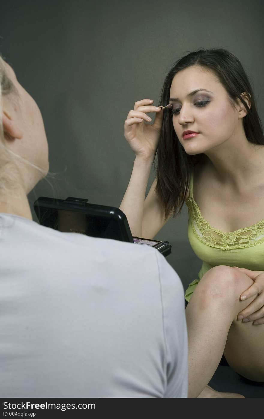 Young brunette applying eye shadow. Young brunette applying eye shadow