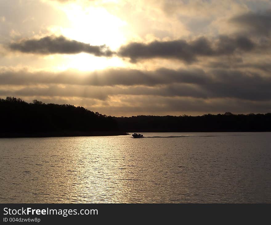 Lake sunset with fishing boat