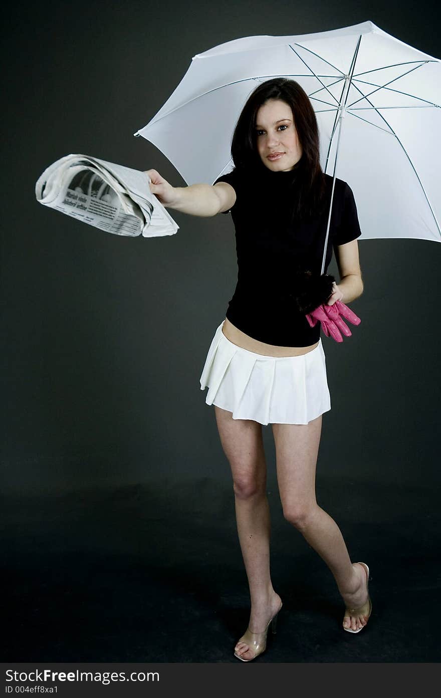 Young girl handing out a paper from under a white a umbrella. Young girl handing out a paper from under a white a umbrella