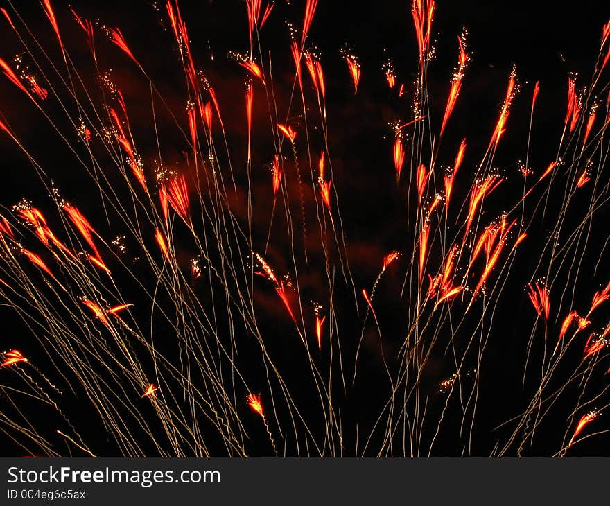 Fireworks blossoming upwards in shades of orange and red bursts. Fireworks blossoming upwards in shades of orange and red bursts