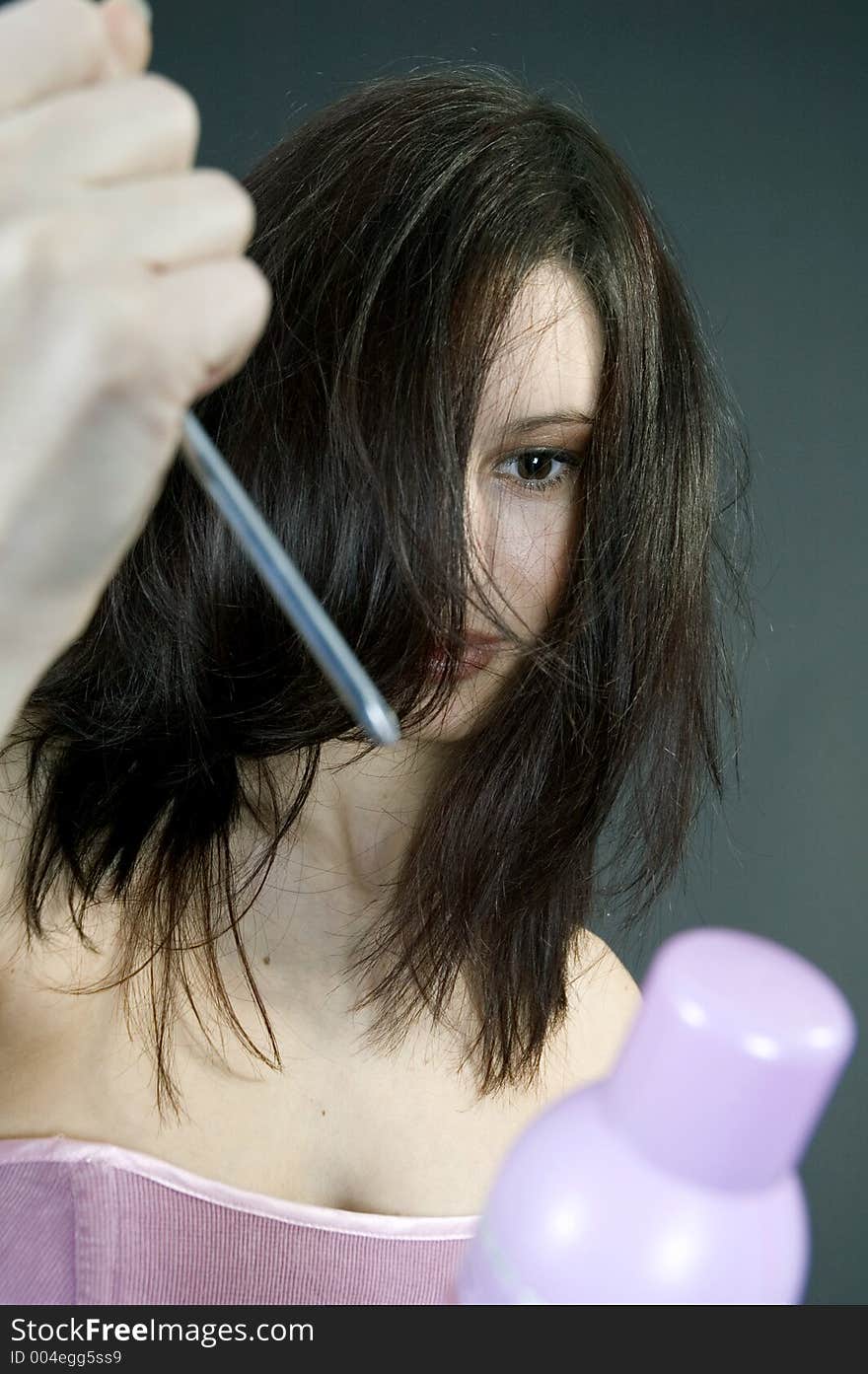 Young woman trying to stab a hair spray. Young woman trying to stab a hair spray