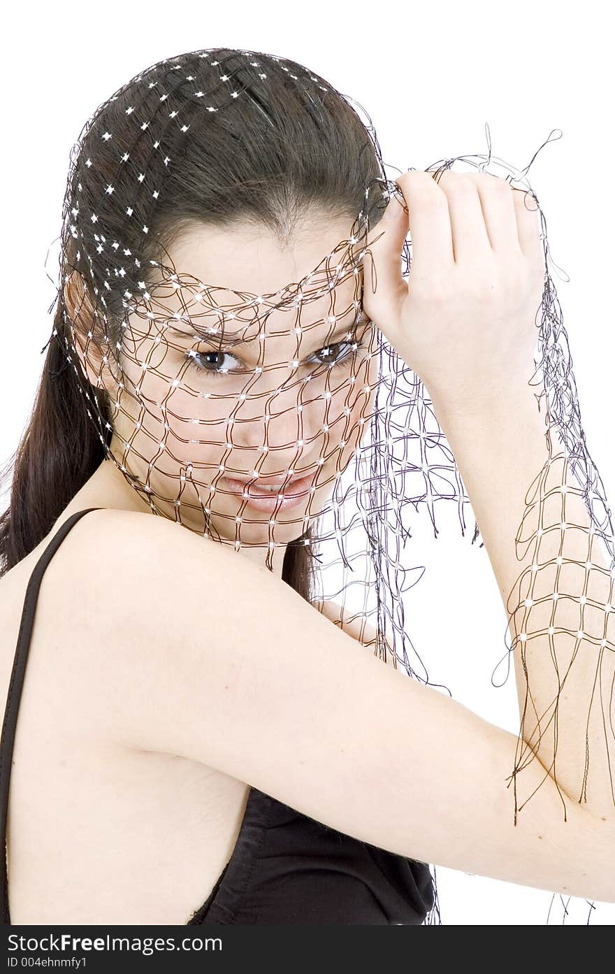 Pretty young brunette with a fresh, fit look, playing with a net shawl over a white studio background, with an expression of purity on her face. Pretty young brunette with a fresh, fit look, playing with a net shawl over a white studio background, with an expression of purity on her face