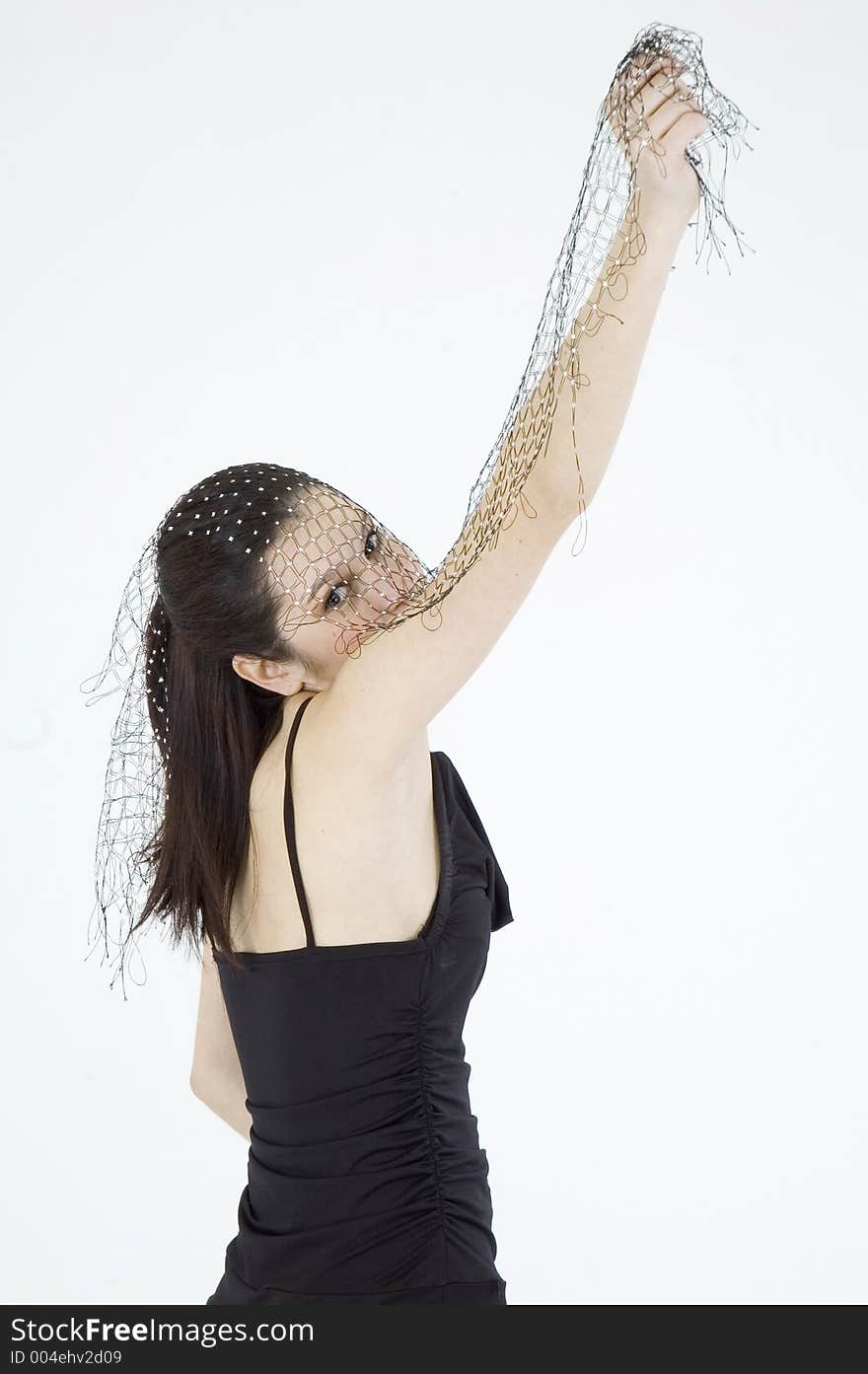 Pretty young brunette with a fresh, fit look, dressed in a short, light, black dress and playing with a net shawl over a white studio background, performs various postures and expressions. Pretty young brunette with a fresh, fit look, dressed in a short, light, black dress and playing with a net shawl over a white studio background, performs various postures and expressions