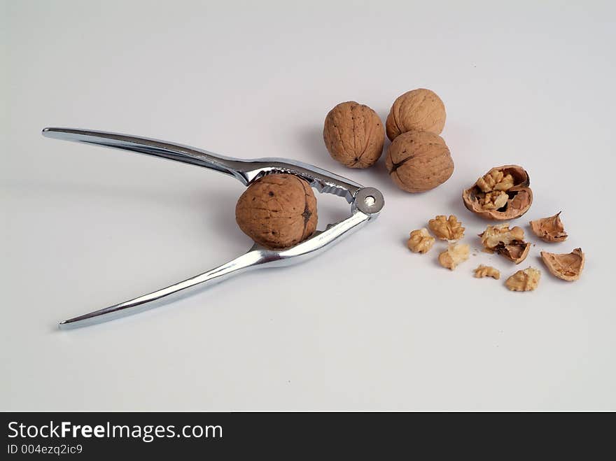 Studio shot of wallnuts and a nutcracker.