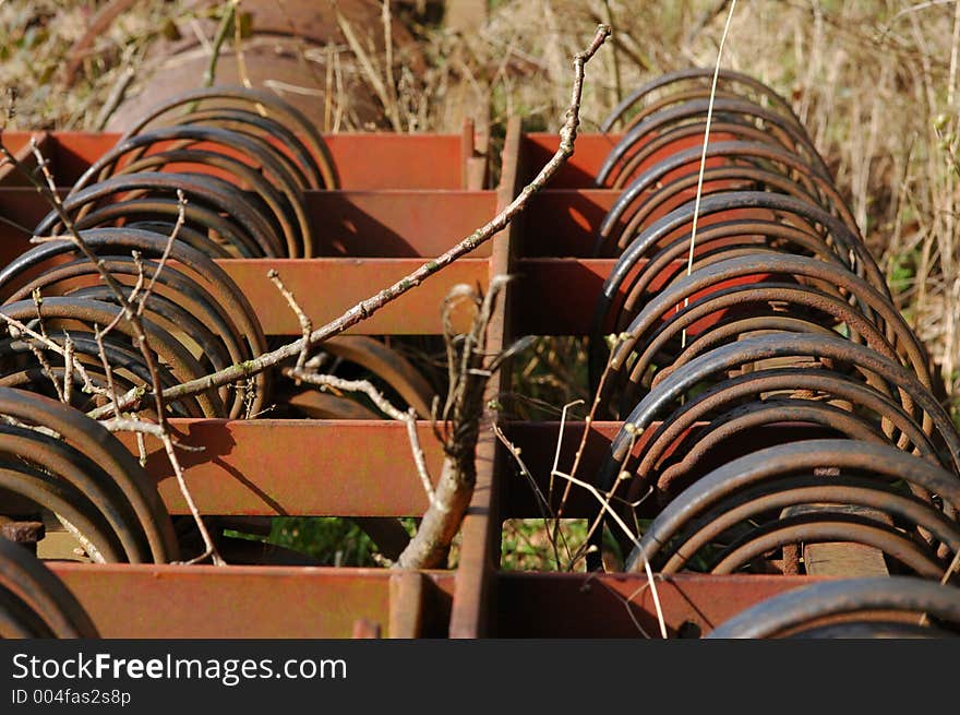 Disused rusty farm machinery lying in a field